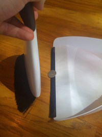 Broom sweeps quarter onto dustpan